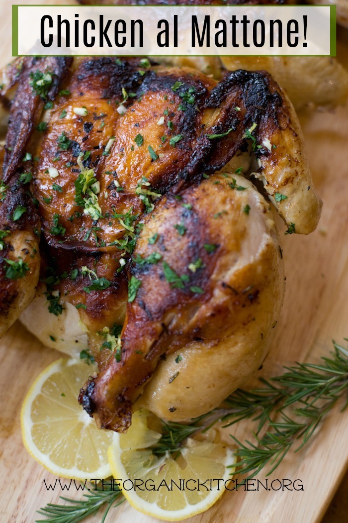 Roasted Chicken al Mattone!~ Paleo, Whole 30 garnished with lemons and parsley on a cutting board