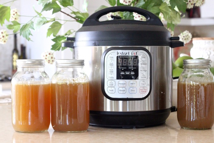 A Instant Pot with mason jars of homemade chicken broth