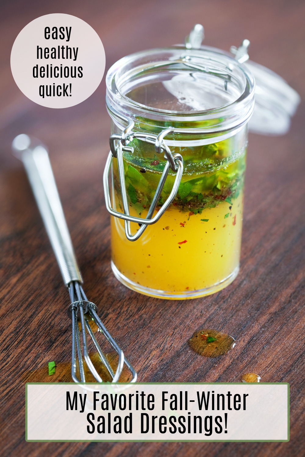 My Favorite Fall/Winter Salad Dressings! A jar of lemon vinaigrette with chives in a glass jar with a small whisk on the counter