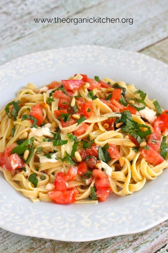 A light blue bowl with scalloped edges filled with Fettuccine with Tomatoes and Burrata Cheese