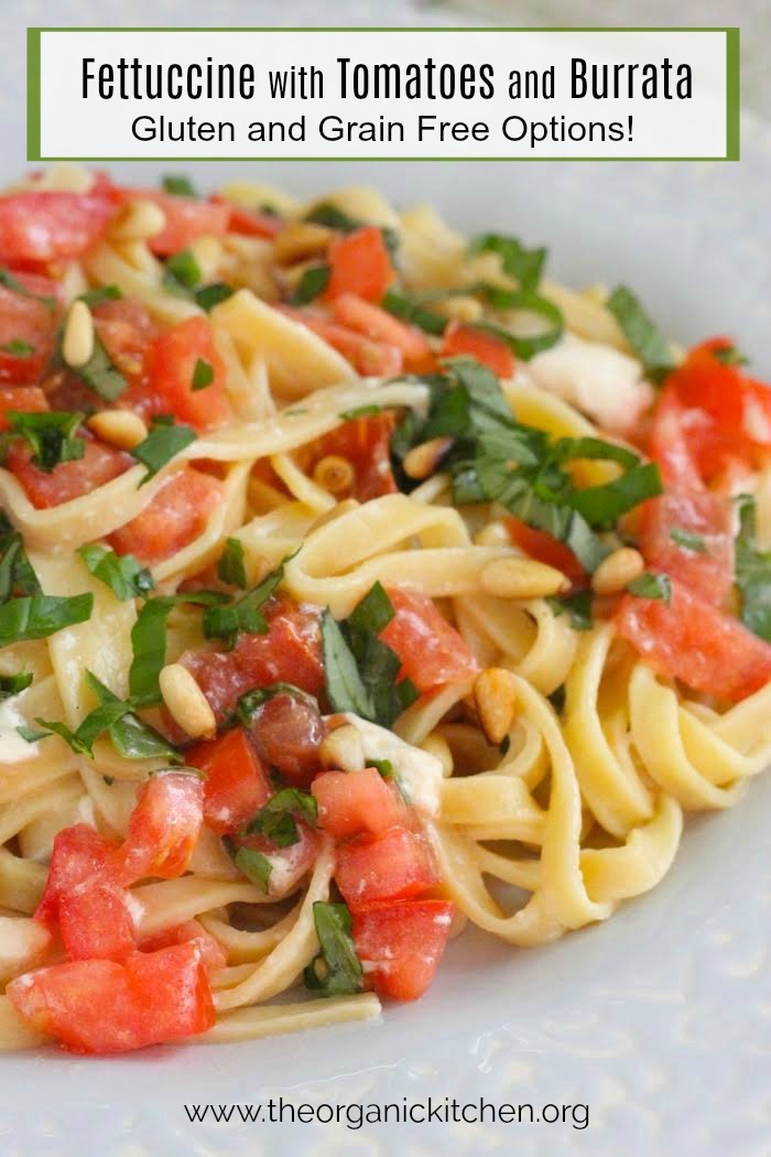 Fettuccine with Tomatoes and Burrata Cheese garnished with basil and pine nuts on light blue plate