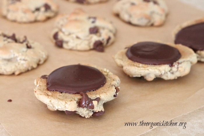 Chocolate chip cookies with drizzled chocolate on baking sheet