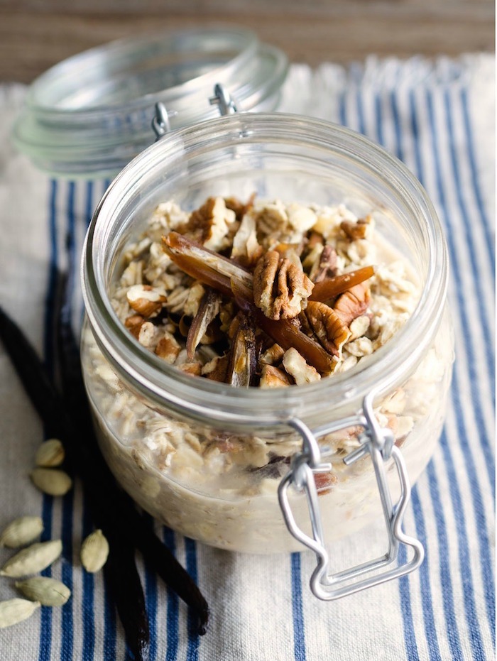 A mason jar filled with Grab and Go Maple Vanilla Overnight Oats topped with pecans 