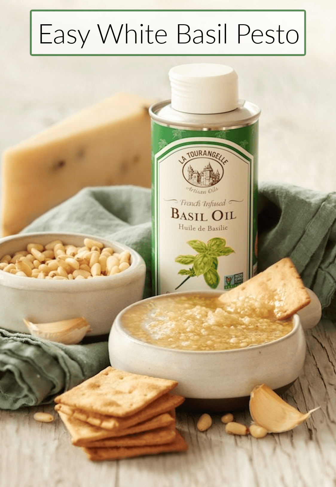 Easy White Basil Pesto A bowl of Easy White Basil Pesto surrounded by basil oil, a bowl of pine nuts and crackers
