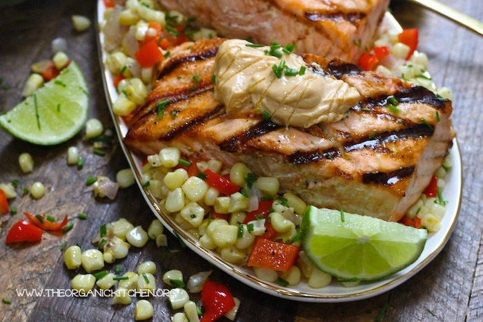 Salmon with Corn Hash and Chipotle Lime Mayo garnished with lime wedges and chives