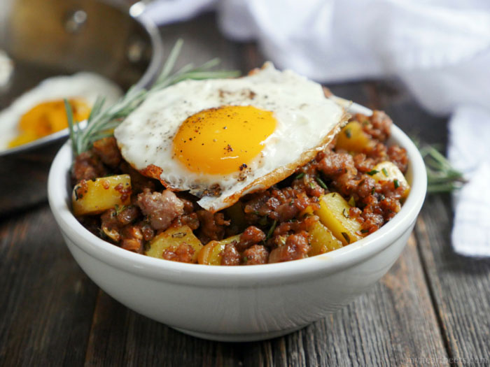 aA white bowl of breakfast hash with a fried egg on top as part of 12 Healthy, Delicious (Whole 30) Breakfast Recipes!