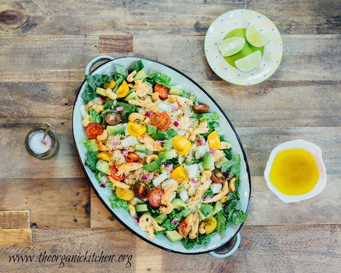 Chicken and Quinoa Salad on green platter with dishes of sea salt, lime wedges, and lime vinaigrette