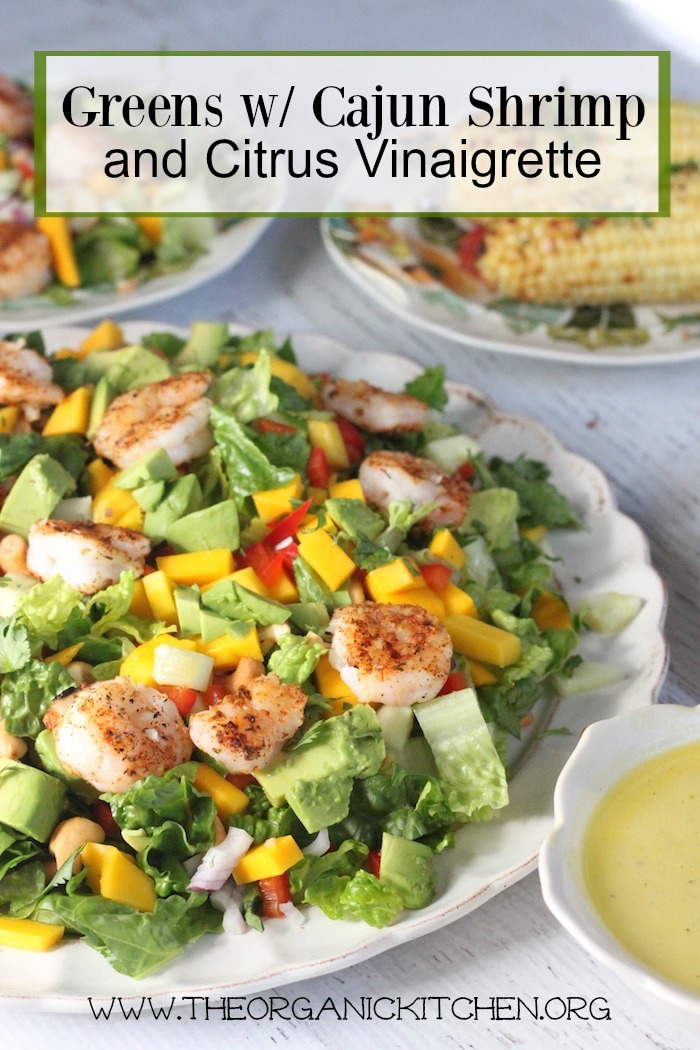 Greens with Grilled Shrimp and Citrus Vinaigrette on a white plate