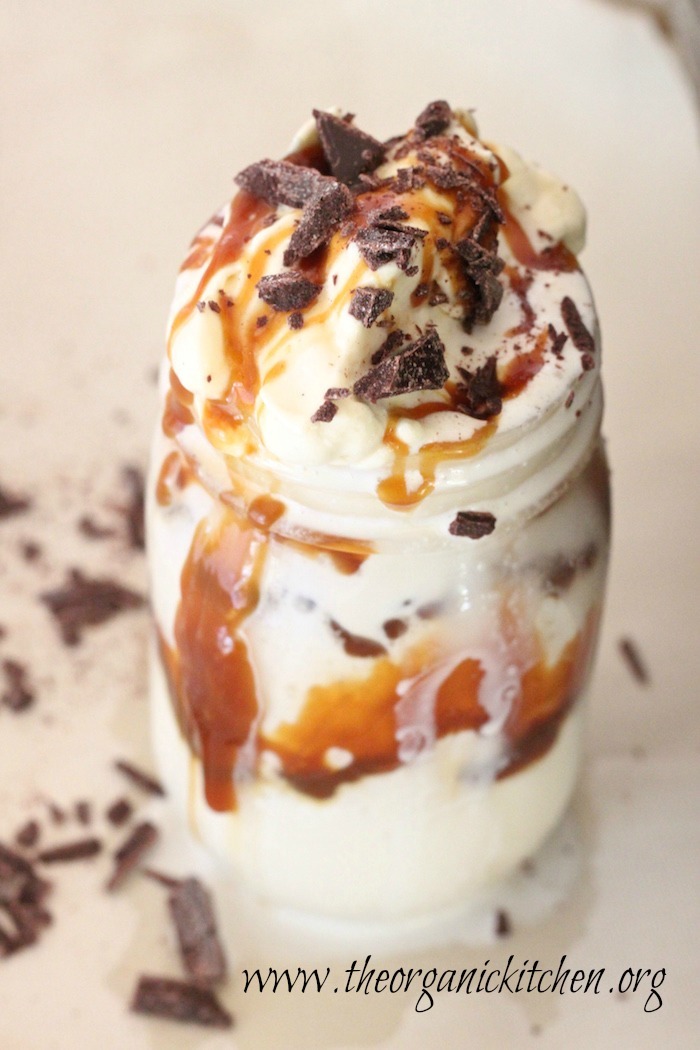 Salted Caramel Ice Cream Shake with Chopped Chocolate in a mason jar on white surface