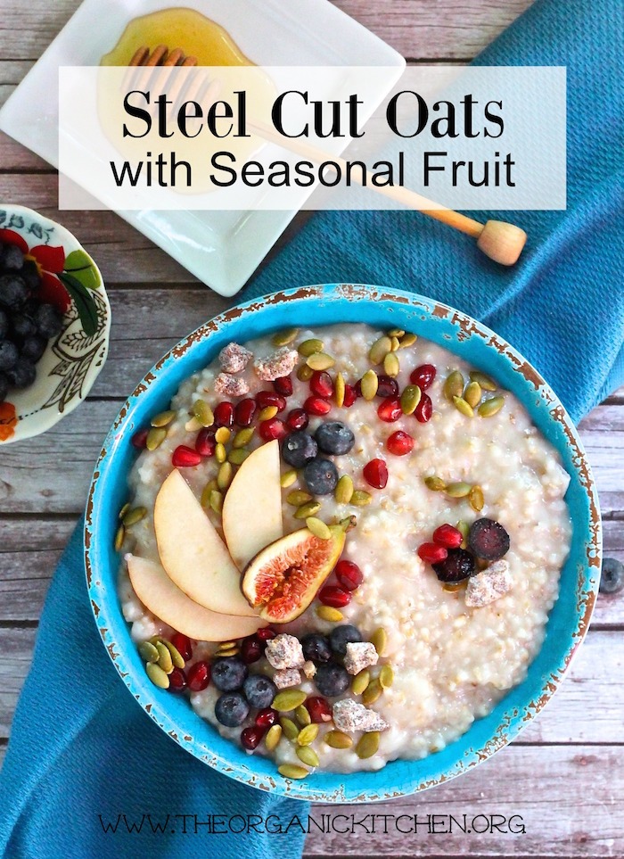 Steel-Cut Oats with Seasonal Fruit in blue bowl on wood table with blue dish towel