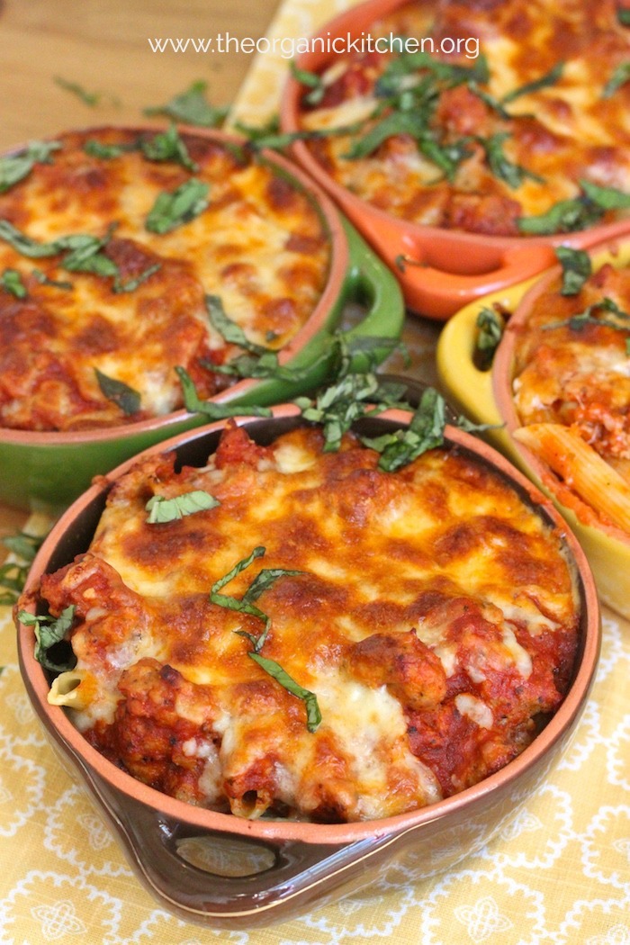 Easy Baked Penne with Italian Sausage topped with basil in baking dishes 