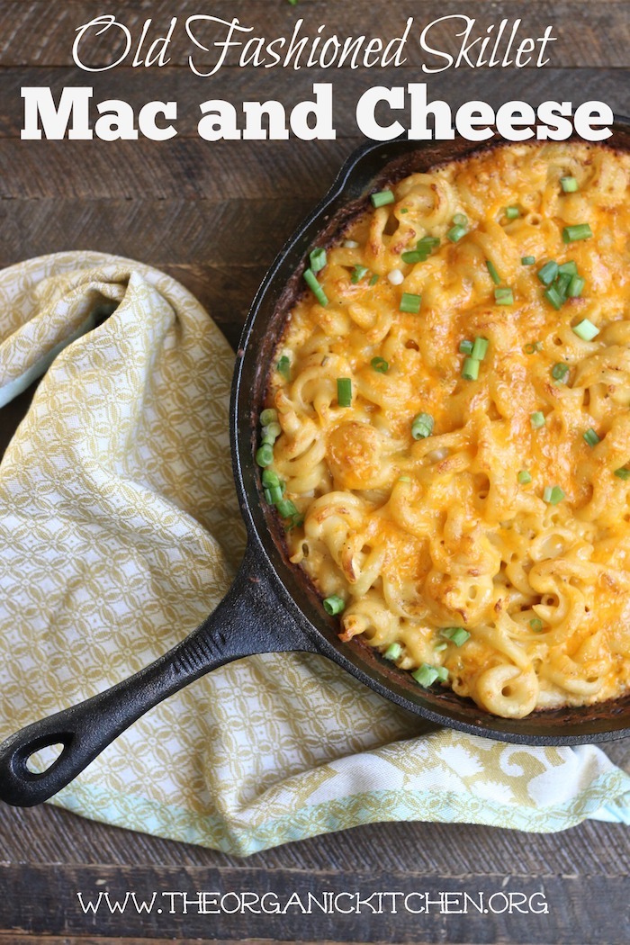 Old Fashioned Skillet Macaroni and Cheese garnished with green onions and set on a yellow dish towel on a wooden table