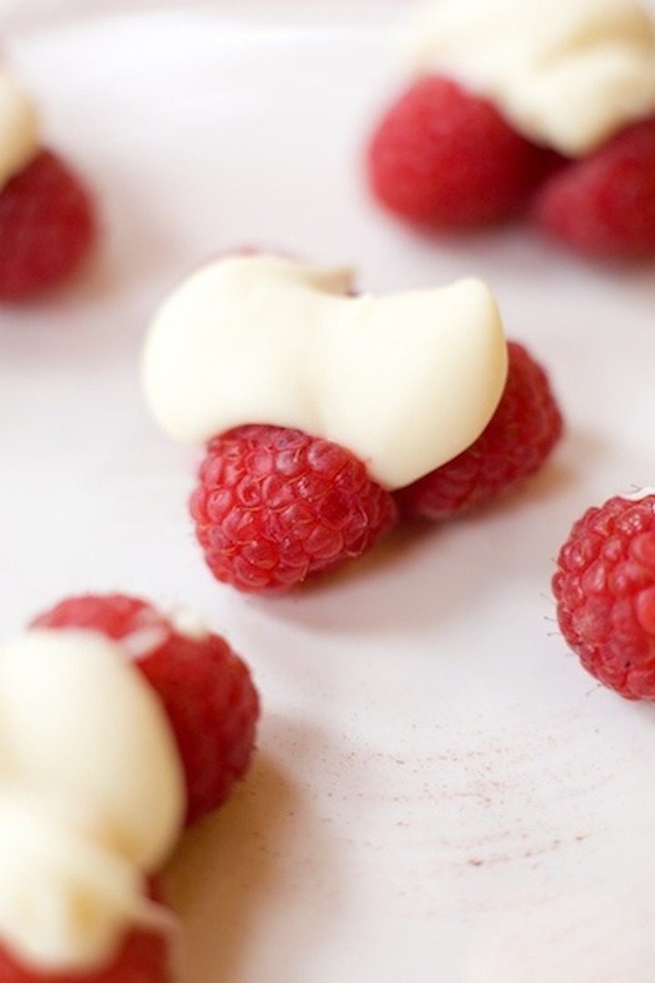 My Favorite Holiday Desserts Raspberries topped with white chocolate on a white plate