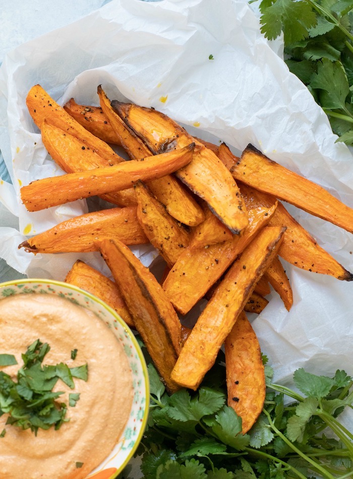 Easy Baked Sweet Potato Wedges with Chipotle Cashew Dip garnished with cilantro