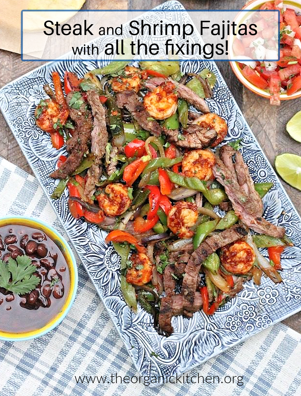 Steak and Shrimp Fajitas with all the Fixings on a blue plate surrounded by bowls of black beans and salsa