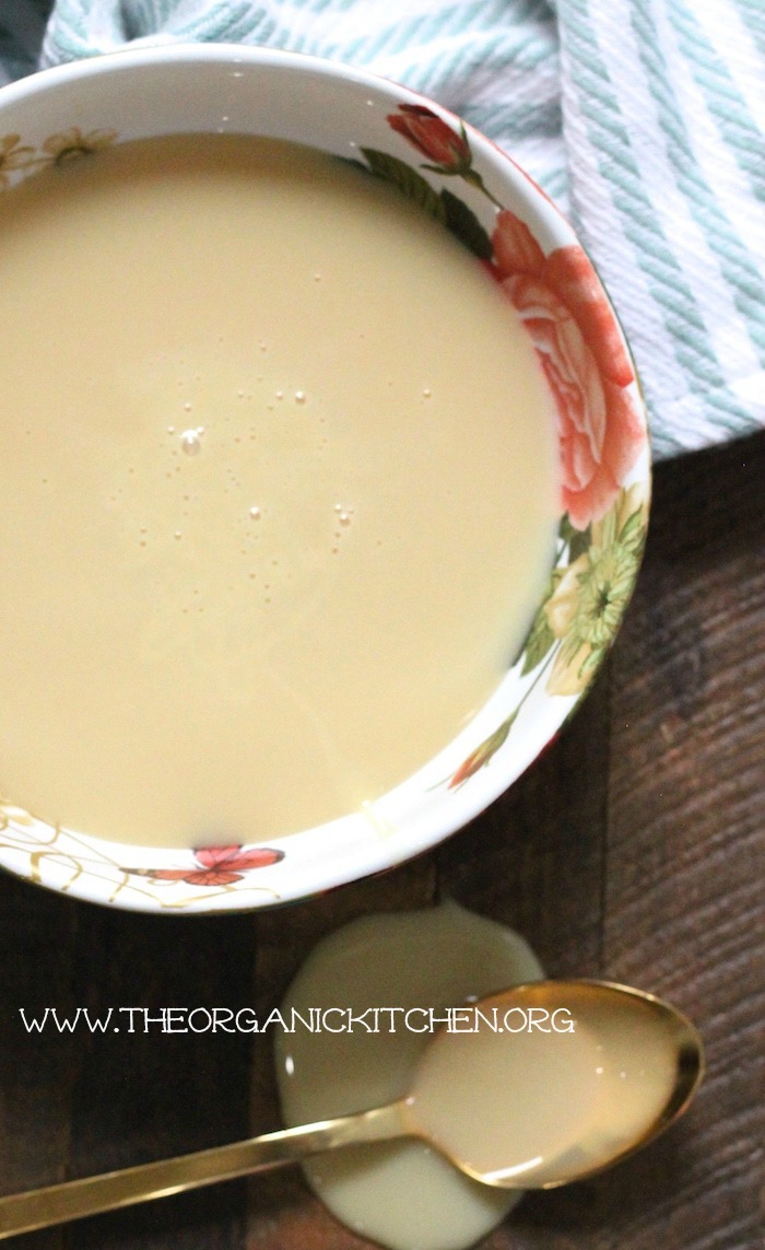 Homemade Sweetened Condensed Milk in a colorful bowl with a gold spoon