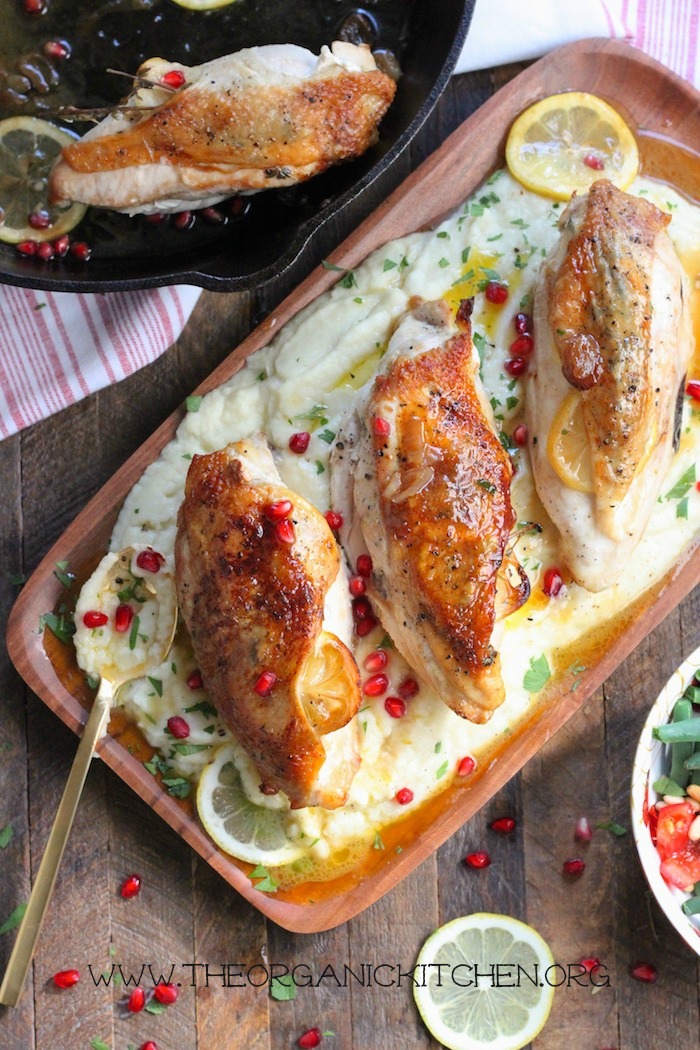 Paleo Roast Lemon Chicken with Maple Cauliflower Purée on a wooden platter next to a black cast iron skillet
