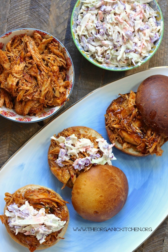 BBQ Pulled Chicken Sandwiches with Creamy Coleslaw on blue platter with a bowl of BBQ pulled chicken and a bowl of coleslaw