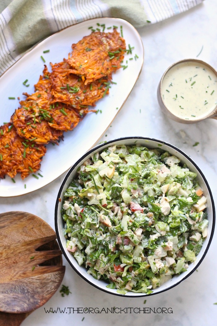 Easy Sweet Potato Fritters-Paleo/Whole 30 on a platter next to a large bowl of salad