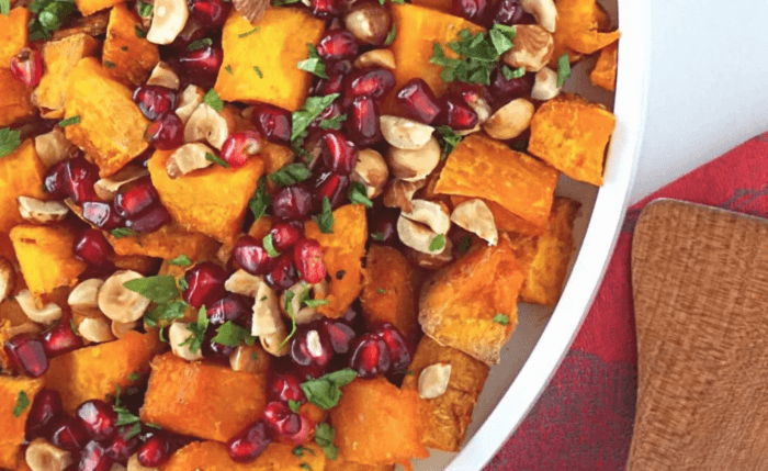 A white bowl filled with roasted squash, hazelnuts and pomegranate seeds: 12 Healthy Whole30 Vegetable Side Dishes! 