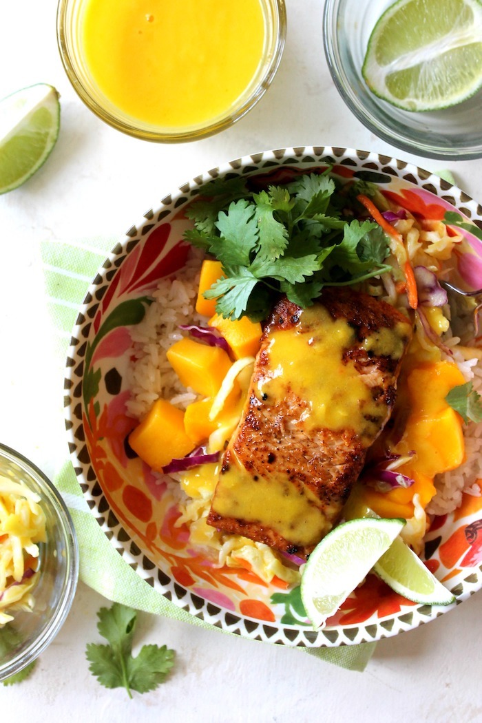 A salmon rice bowl garnished with cilantro and mango as part of 12 Fantastic Rice Bowl Recipes!