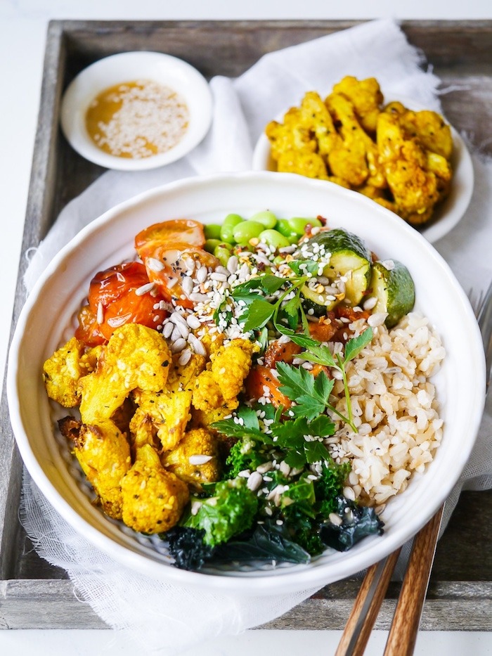 A rice bowl topped with colorful vegetables and herbs as part of 12 Fantastic Rice Bowl Recipes!