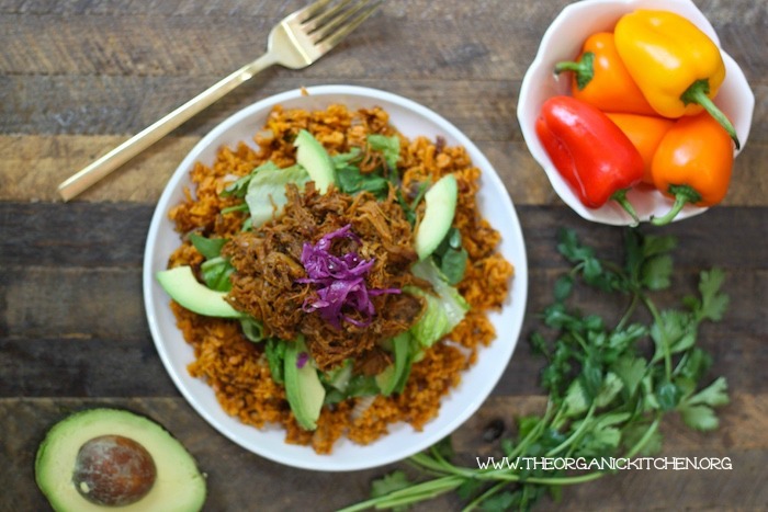 Pulled Pork over Mexican Sweet Potato Rice- Paleo/Whole30 on a white dish with a bowl or red, yellow, and orange sweet bell pappers