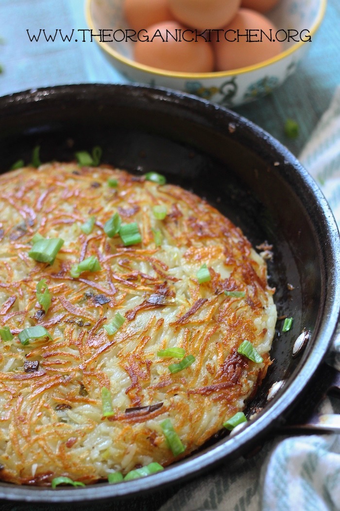 Traditional Swiss Rosti in black pan with a bowl of eggs in the background