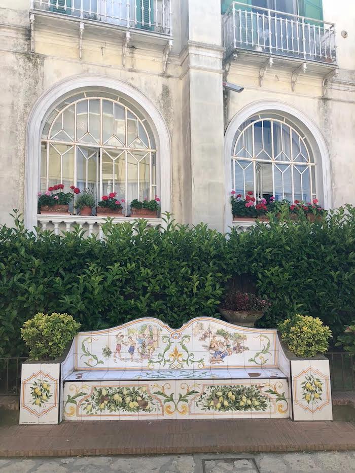 A beautiful white washed building with arched window and flower boxes  on the Island of Capri