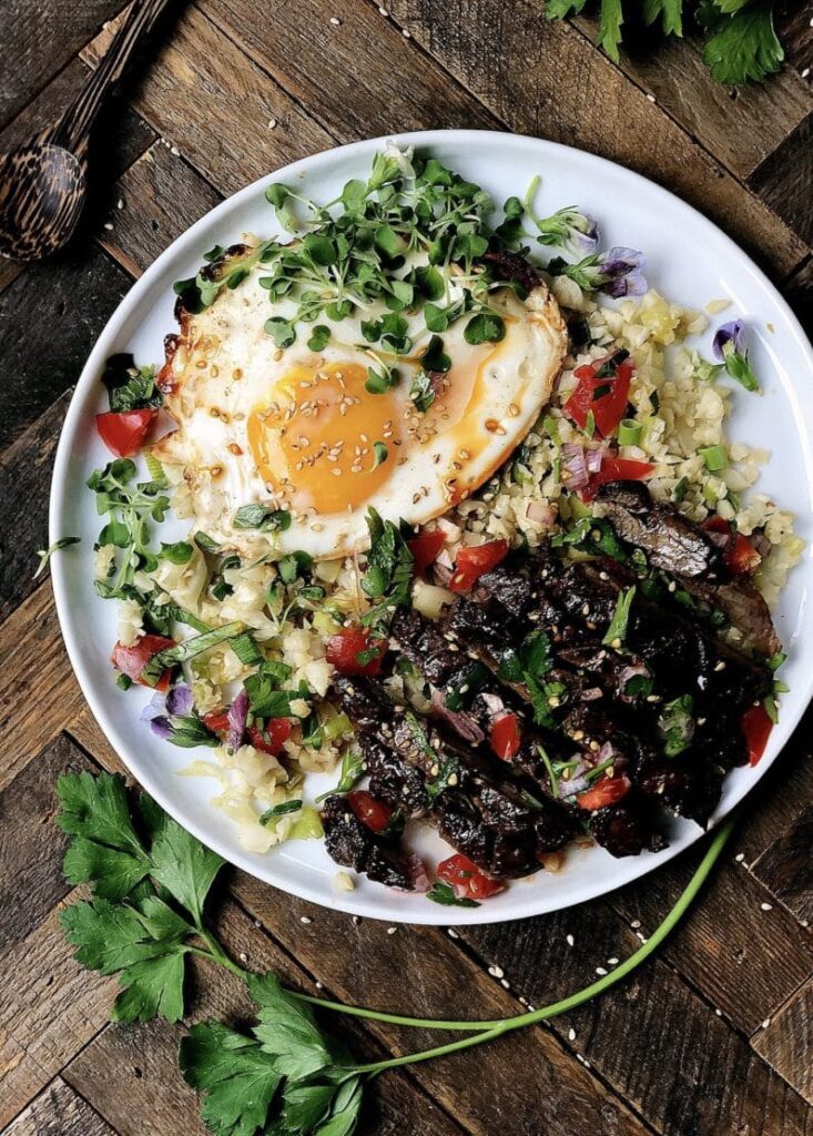 10 Incredible Whole30 Steak Dinner Recipes Steak, eggs and cauliflower rice on white plate