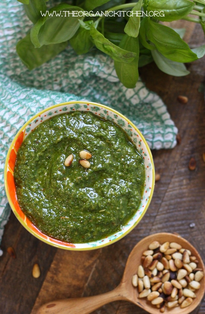 A colorful bowl filled with bright green fresh basil pesto to be used on Pesto Salmon