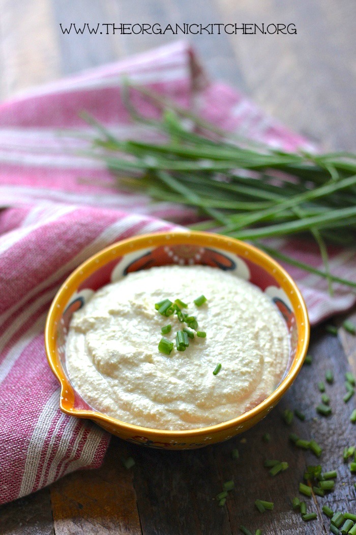 Cashew cheese sauce in a small bowl with dish towel and chives in the background. 20+ Whole30 Dips, Sauces and Salad Dressings! 