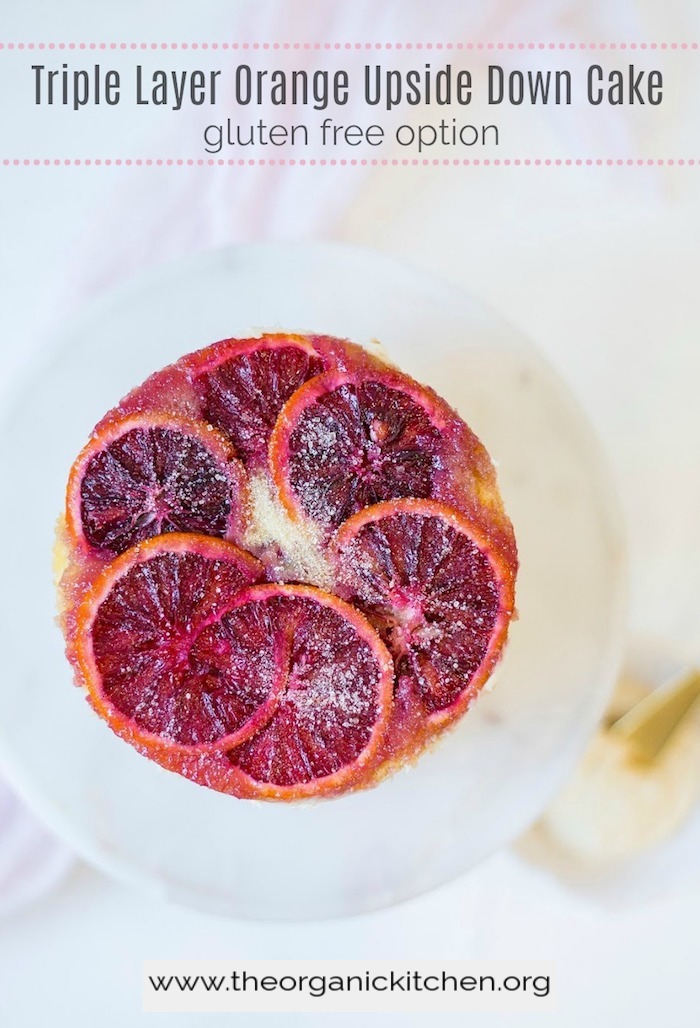 Triple Layer Orange Upside Down Cake sprinkled with on a white cake plate 