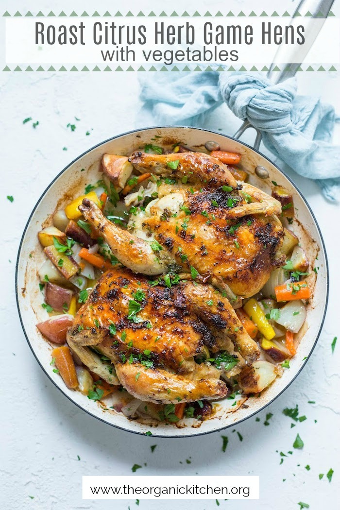 Roasted Citrus Herb Game Hens with Vegetables in a white pan 