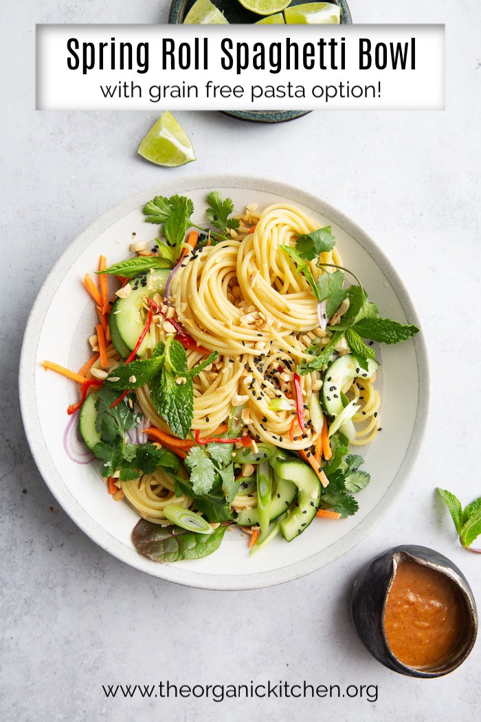 Spring Roll Spaghetti Bowl (Grain Free Option!) on a white plate with lime wedges and salad dressing
