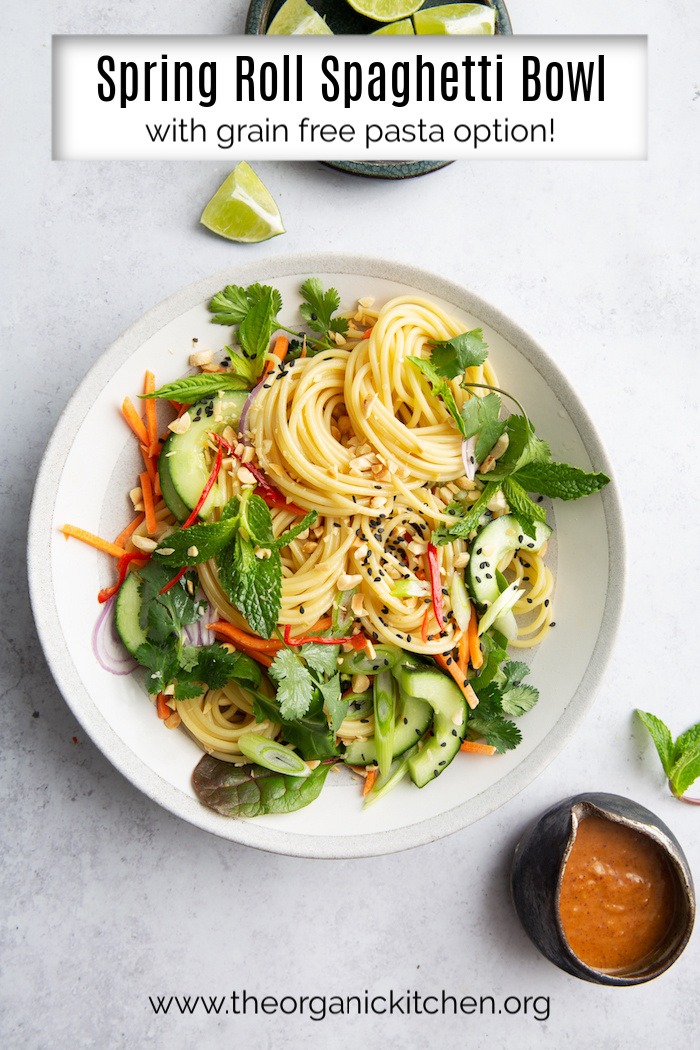 Spring Roll Spaghetti Bowl (Grain Free Option!) on a white plate with lime wedges and salad dressing