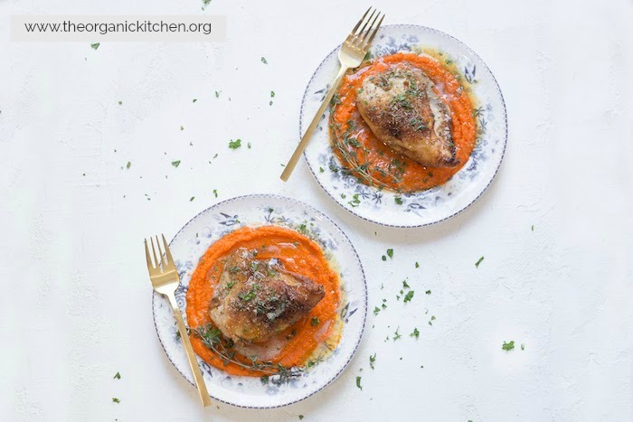 Two plates of Herbed Chicken Breast with Carrot Purée and Brown Butter garnished with parsley placed side by side