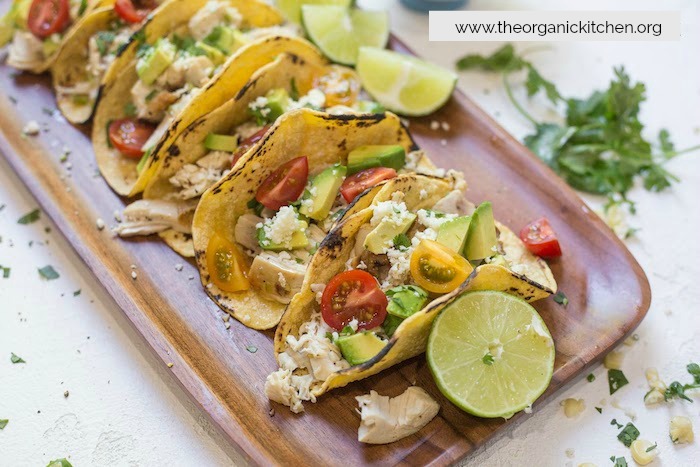 Easy Garlic Lime Chicken Tacos with Lime Crema garnished with lime wedges and cilantro