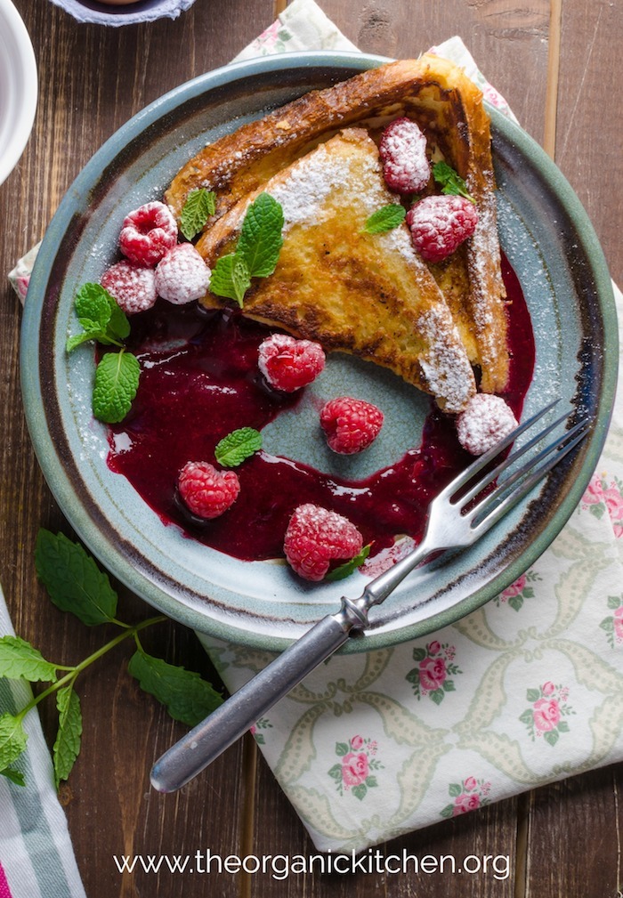 French toast with raspberry compote on gray plate with flowered napkin underneath