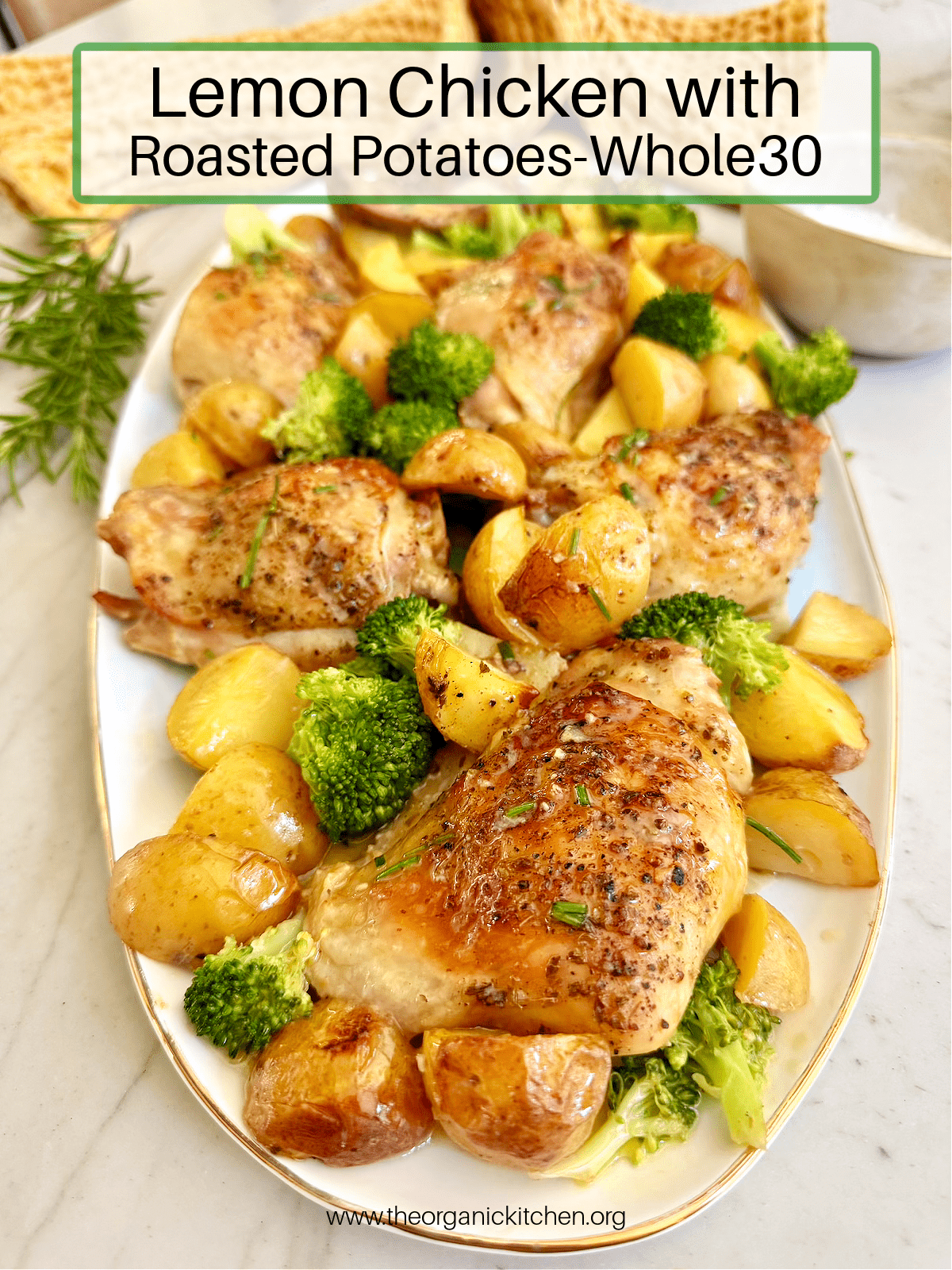 Lemon Chicken with Roasted Potatoes and broccoli on white platter with herbs and yellow dish towel in background