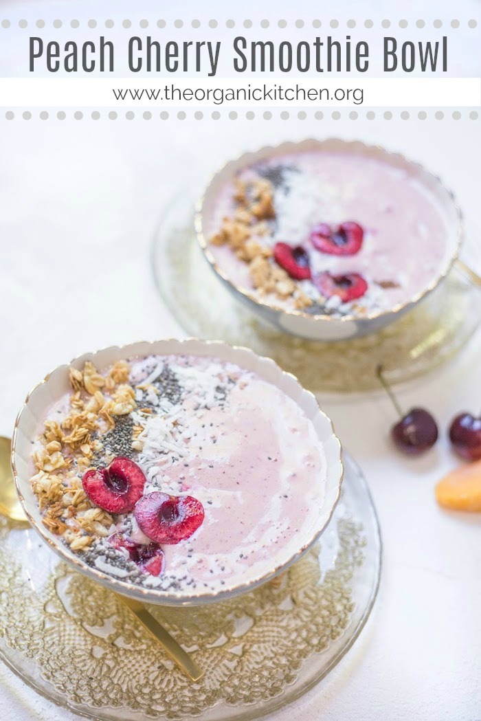 Two Peach Cherry Smoothie Bowls on gold laced plates topped with cherries, granola and chia