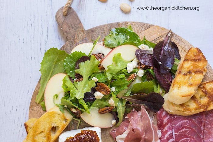 Salad and Charcuterie Board Dinner on white backdrop scattered with almonds