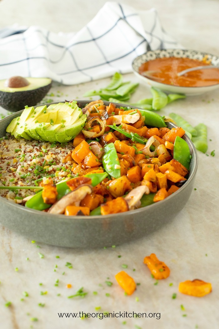 Copycat True Food Kitchen Ancient Grain Bowl in gray bowl with avocado and bowl of sauce in background