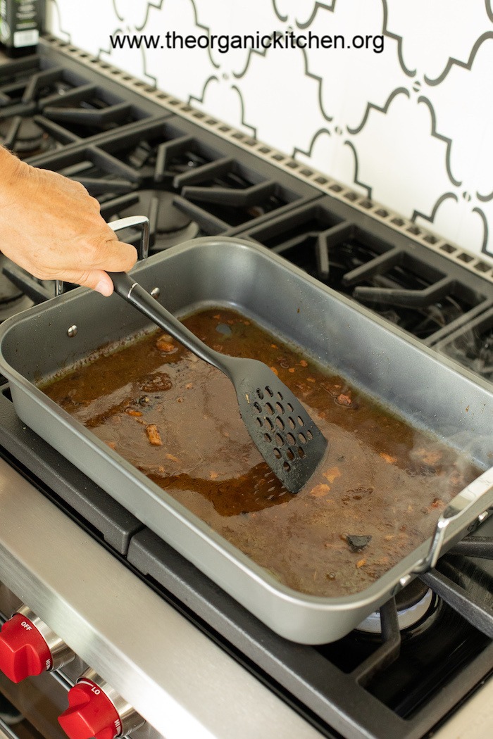 A man holding a spatula demonstrating How to Make Turkey Gravy with Drippings