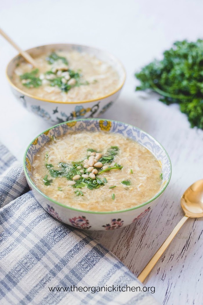 Two bowls of Italian Egg Drop Soup with blue and white dish towel in foreground