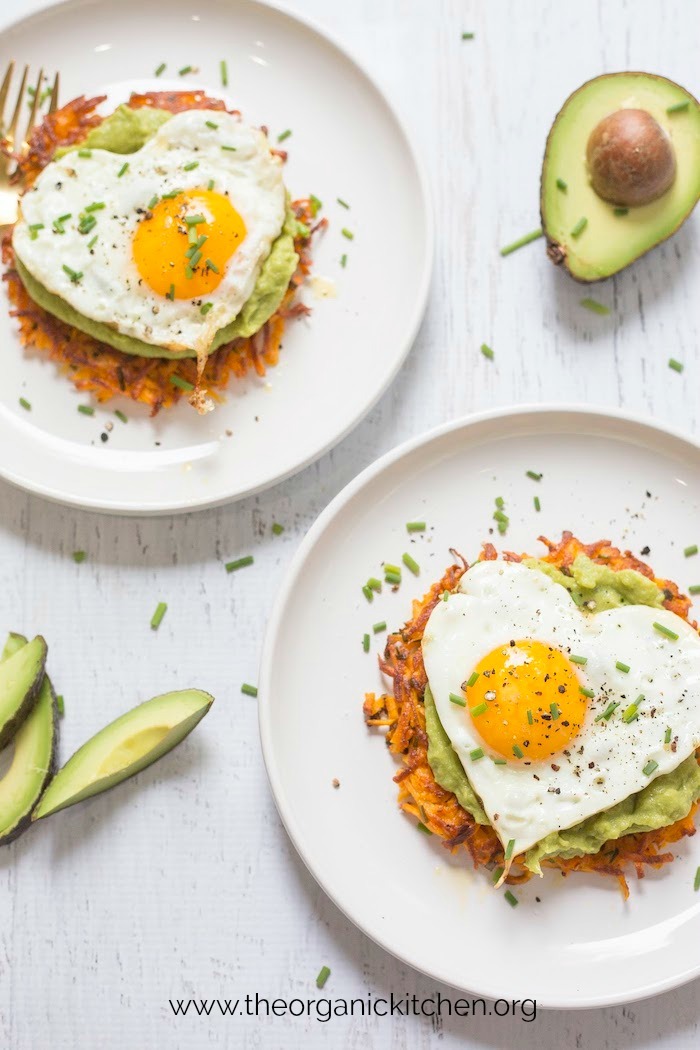 Savory Sweet Potato Fritters with Avocado and Fried Eggs on white plates garnished with avocado