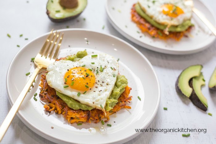 Savory Sweet Potato Fritters with Avocado and Fried Eggs on white plate with gold fork