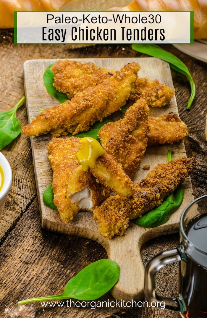 Keto-Paleo-Whole30 Easy Chicken Tenders on wooden cutting board garnished with greens