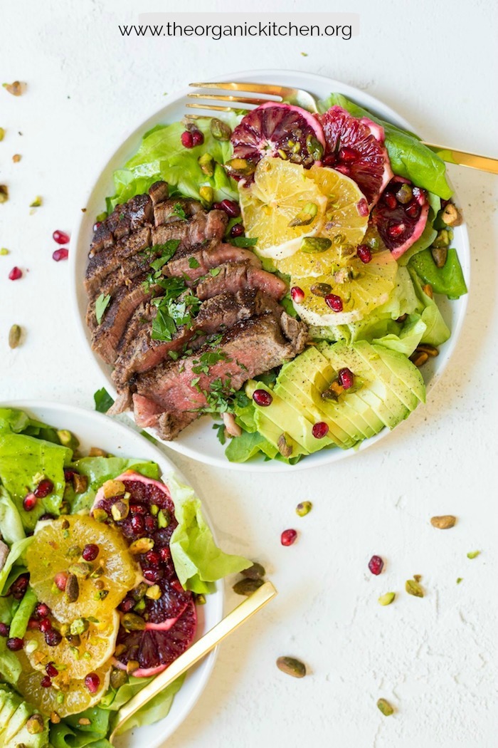 Steak with Citrus and Avocado Salad on white plates on white table
