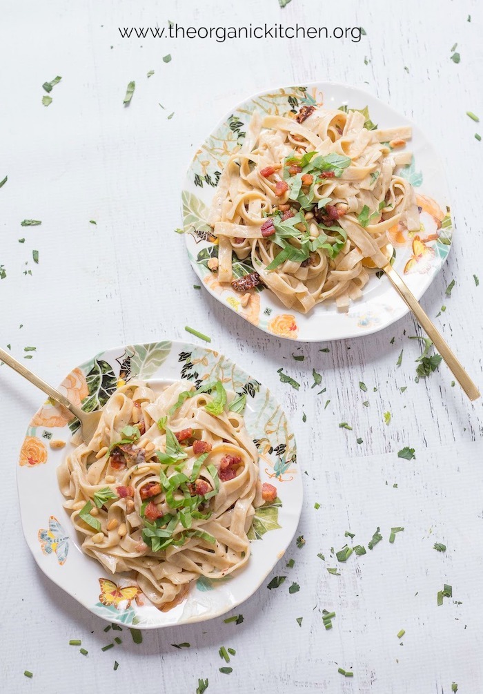 Two plates of Simple Fettuccine Alfredo with gold forks on white wood